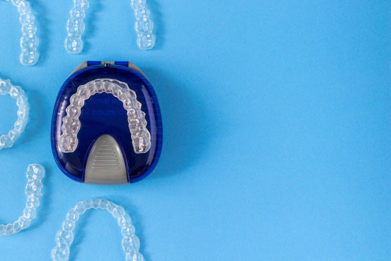 Top View Of An Invisalign Retainer Tray On A Blue Surface