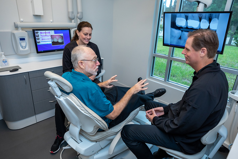 a patient during his dental implants consultation at Caven Dental Group