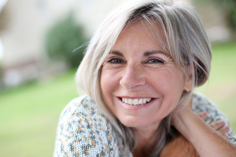 an image of a dental patient smiling with dental implants.